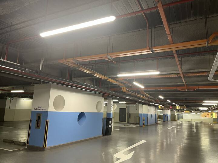 Surface-mounted linear LED fittings over parking bays and circulation aisles